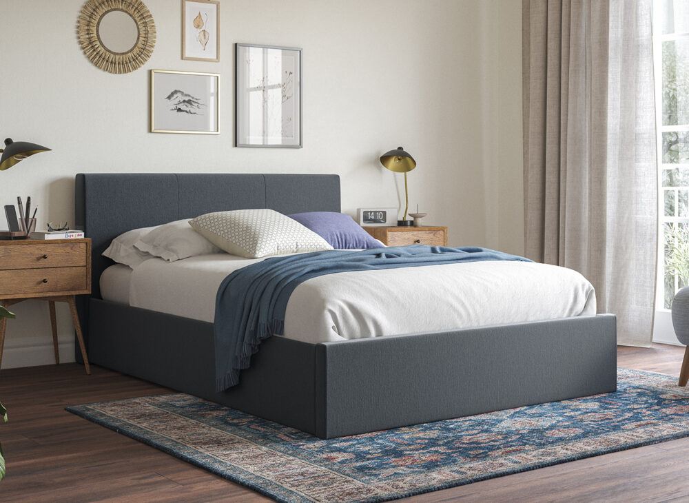 Yardley grey fabric ottoman bed frame with white bedding and scatter cushions