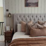 Beige buttoned bed frame, styled with autumnal decorations including brown and rust bedding